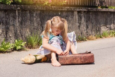 Une petite fille range ses cahiers dans son cartable