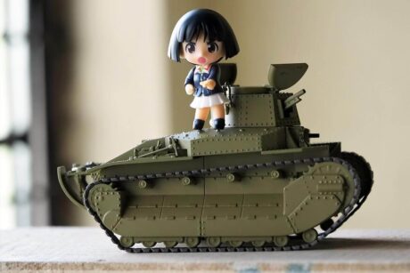 Une fillette en jouet sur un char de guerre